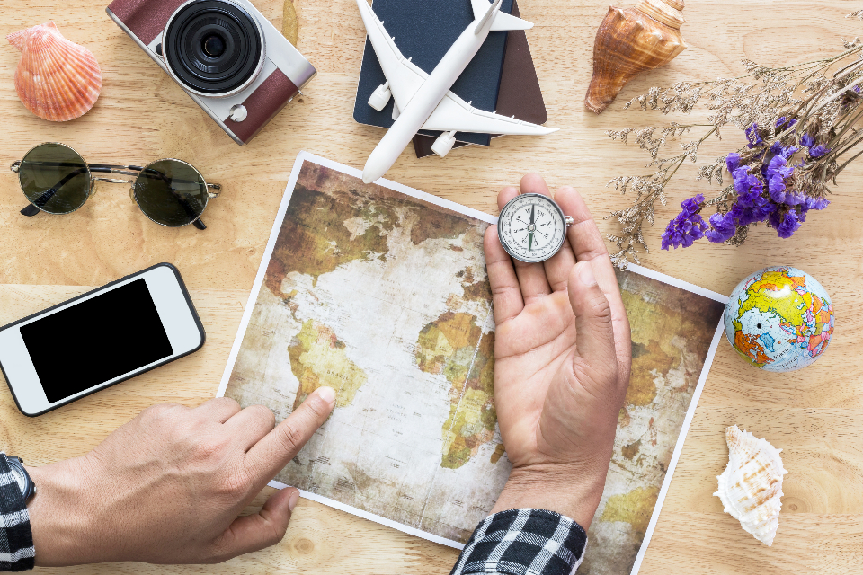 Traveller planning a trip with a map and compass